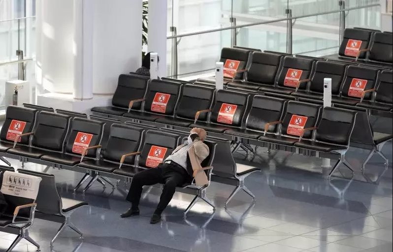 日本 Omicron 疫情緊張，圖為一名男子獨自坐在機場大廳中。